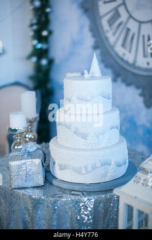 Tre-strato bianco holiday torta sul tavolo decorato con abeti e confezione regalo Foto Stock