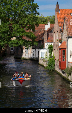 Turisti che si godono una città crociera lungo i canali di Bruges, Belgio Foto Stock