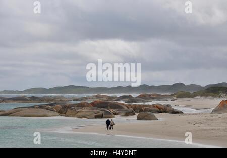 La Danimarca,WA,Australia-October 2,2014:Coppia di anziani camminare il verde del telecomando in piscina e spiaggia rocciosa durante una tempesta in Danimarca, Western Australia. Foto Stock