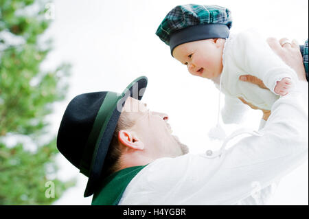 Padre sollevando la sua piccola figlia in aria Foto Stock