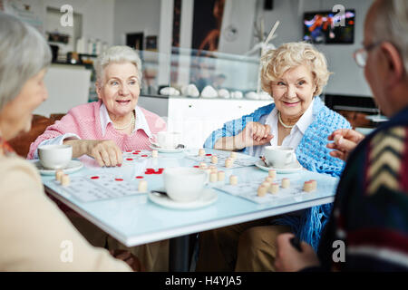 Senior amici riproduzione lotto nel tempo libero Foto Stock