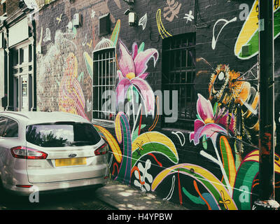 Graffiti di un ape e fiori su una parete di Camden Town, Londra, Regno Unito Foto Stock