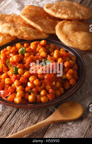 Cucina Indiana: Chana masala e puri pane vicino sul tavolo. In verticale Foto Stock