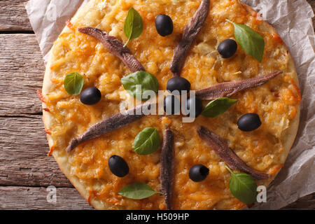 Pissaladiere con acciughe, olive e cipolla vicino sul tavolo. Orizzontale vista superiore Foto Stock