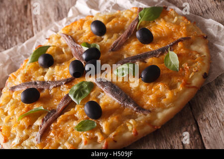 Pissaladiere con acciughe, olive e cipolla vicino sul tavolo orizzontale. Foto Stock