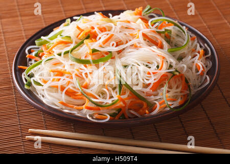 Tagliatelle cinesi con il cetriolo e la carota su una piastra di close-up orizzontale. Foto Stock