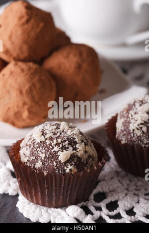 Delizioso tartufo al cioccolato caramelle macro su una tovaglia di pizzo verticale. Foto Stock