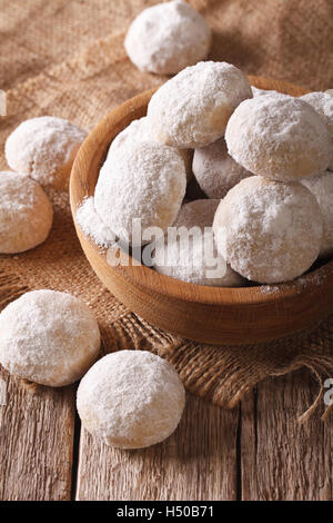 Biscotti Frollini con dadi da vicino in una ciotola di legno sul tavolo. verticale, stile rustico Foto Stock