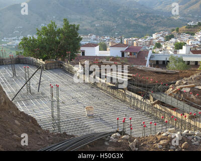 Nuovo pavimento di calcestruzzo colato con maglia di acciaio e pali Foto Stock