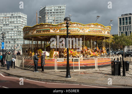 Una rotatoria o merry-go-round Fairground Ride da Pier Head sul lungomare di Liverpool Merseyside England Regno Unito Regno Unito Foto Stock