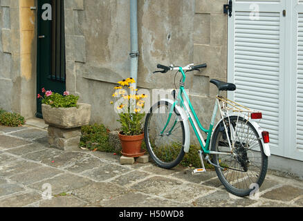 Un signore bicicletta si appoggia contro un muro di casa Francia Foto Stock