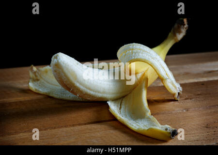 Banana pelata su un tavolo rustico closeup Foto Stock