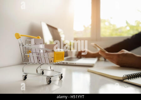 Internet shopping online concetto con smartphone e shopping-cart.tono Vintage retrò effetto filtro, soft focus (messa a fuoco selettiva) Foto Stock