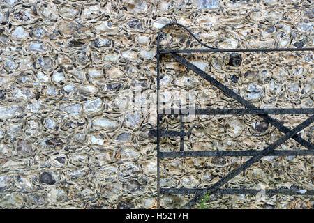 Ferro battuto cancello nella parte anteriore di una pietra focaia e la costruzione di pietra parete in corrispondenza del Weald and Downland Open Air Museum, Singleton, Sussex, Inghilterra Foto Stock