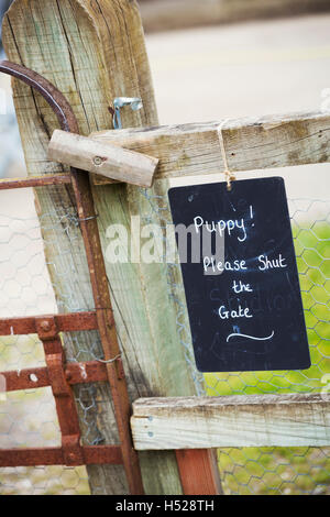 Un segno di gesso su un garden gate cucciolo! Si prega di chiudere il portone. Foto Stock