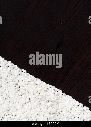 White il riso crudo su uno sfondo scuro. Foto Stock