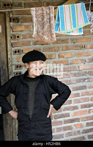 Donna con sorriso priva di denti al di fuori la sua casa nella provincia di Ha Giang, Vietnam del Nord Foto Stock