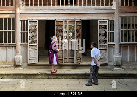 Uomo e donna che parlano all'interno Vuong Palace in Sa Phin, Ha Giang Provincia del Vietnam del Nord Foto Stock