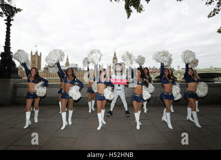 Il Los Angeles Rams Cheerleaders, lungo con mascotte Rampage, che esegue una routine di fronte alla Casa del Parlamento, Londra, durante la loro visita a un certo numero di punti di riferimento per aggiungere il loro peso nel sostenere il sindaco di Londra #LondonIsOpen campagna. Foto Stock