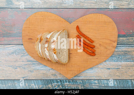 Fette di pane fresco e asciutto salsiccia di fumo sul tavolo di legno Foto Stock