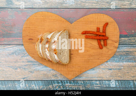 Fette di pane fresco e asciutto salsiccia di fumo sul tavolo di legno Foto Stock