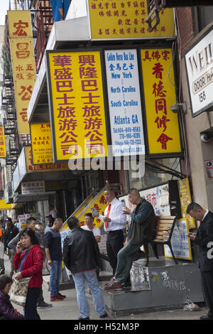 Le persone si mescolano al di fuori del Golden Horse Bus di linea su East Broadway nel quartiere di Chinatown sul Lower East Side di Manhattan, New York. Foto Stock