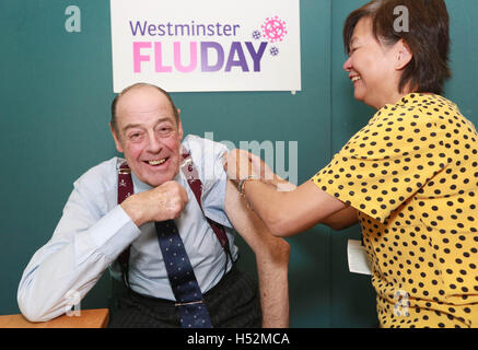 Solo uso editoriale Sir Nicholas Soames, nipote di Sir Winston Churchill e MP per Mid Sussex, ha il suo vaccino amministrato dalla salute infermiere Tessa Redpath a Westminster Flu giorno un vaccino antinfluenzale clinic tenuti nella Camera dei Comuni di Westminster a Londra. Foto Stock