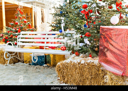 Addobbi per l'albero di Natale, regali, banco, fieno all'esterno. Foto Stock