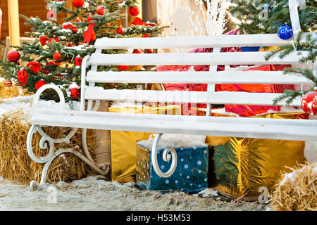 Addobbi per l'albero di Natale, regali, banco, fieno all'esterno. Foto Stock