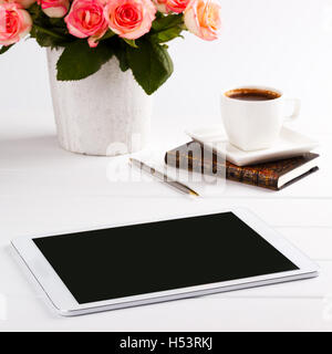 Belle le rose rosa,notepad e tablet bianco sul tavolo di legno, concetto romantico Foto Stock