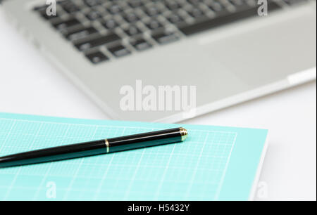 Pc Laptop con penna e notebook in foregorund. Il pc al di fuori della messa a fuoco Foto Stock
