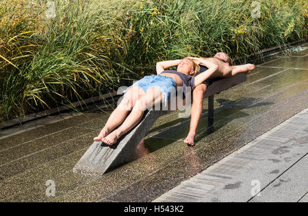 Coppia giovane a prendere il sole sulla linea alta nella città di New York Foto Stock