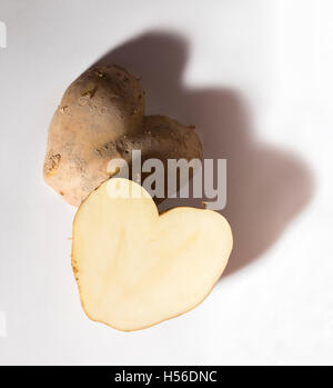 A forma di cuore ad patate tagliate a metà, su uno sfondo bianco. Foto Stock