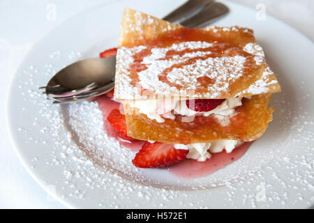 Millefoglie con fragole e zucchero in polvere spruzzata sulla piastra Foto Stock