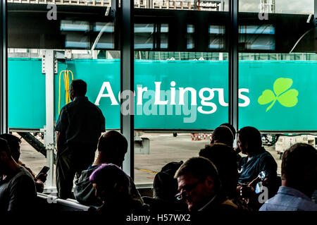 Sala partenze, terminale due, aeroporto di Dublino. I passeggeri in attesa di bordo un Aer Lingus volo, Irlanda Foto Stock