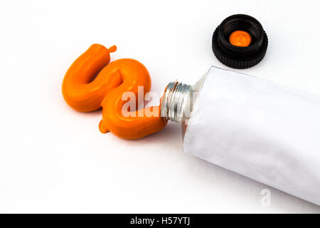 Tubo di arte arancione vernice in prossimità isolata su bianco Foto Stock