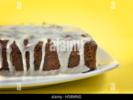 Fatta in casa torta di carote con glassa contro uno sfondo giallo Foto Stock