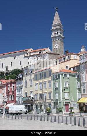 Piazza principale nella città portuale di pirano sulla costa mediterranea della Slovenia. Mostra ben tenute le case e la chiesa al di là della torre Foto Stock