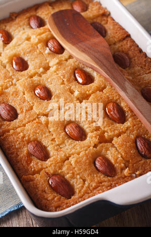 Basbousa (Namoora) con mandorle vicino fino in teglia da forno verticale. Foto Stock