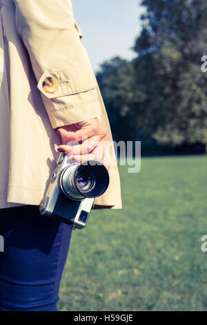 Giovane donna azienda vecchia macchina fotografica in mano Foto Stock