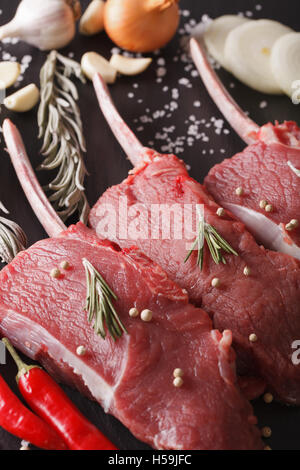 Raw bistecche di manzo con rosmarino su una tavola di ardesia closeup verticale. Foto Stock