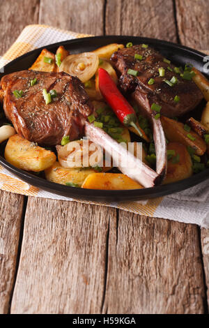 Grigliate di carne di manzo con patate fritte su una piastra vicino sul piano verticale. Foto Stock