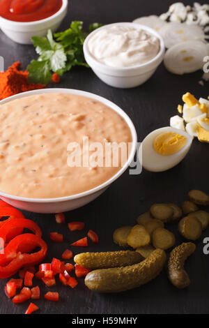 Medicazione di migliaia di isole circondate da ingredienti su di una tavola di close-up. In verticale Foto Stock