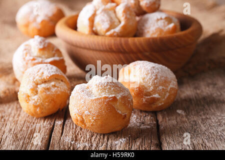 Deliziosi piatti della cucina italiana Castagnole con lo zucchero in polvere di macro sul tavolo orizzontale. Foto Stock