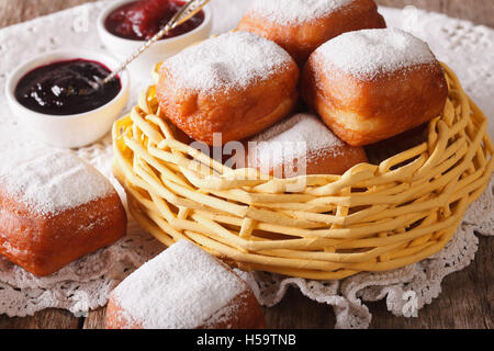 Ciambelle fritte beignets quadrato nel cesto vicino sul tavolo orizzontale. Foto Stock