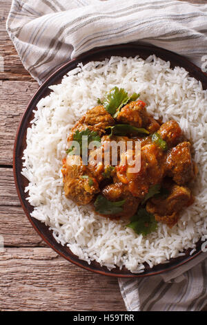 Il cibo indiano: Madras di manzo con riso basmati sul tavolo di close-up. vista verticale da sopra Foto Stock