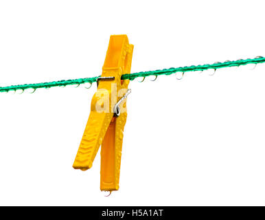 Umido giallo clothespin su un verde linea di lavaggio pieno di gocce di pioggia Foto Stock