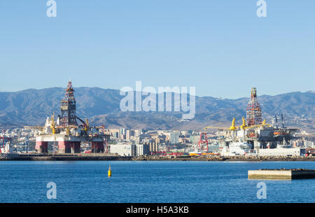 Impianti di trivellazione del petrolio in Las Palmas port (Puerto de la Luz) su Gran Canaria con città e montagna in background. Isole Canarie, Spagna. Foto Stock