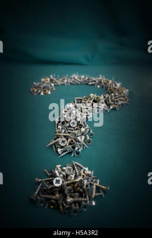 Small Twin-fast viti rivestito a forma di punto interrogativo su sfondo scuro Foto Stock Small Twin-fast viti rivestito a forma di punto interrogativo su sfondo scuro Foto Stock