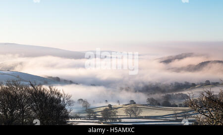 Il tardo inverno, primavera vista guardando verso sud per la nebbia copriva Wharfedale, Yorkshire Dales National Park, England, Regno Unito Foto Stock